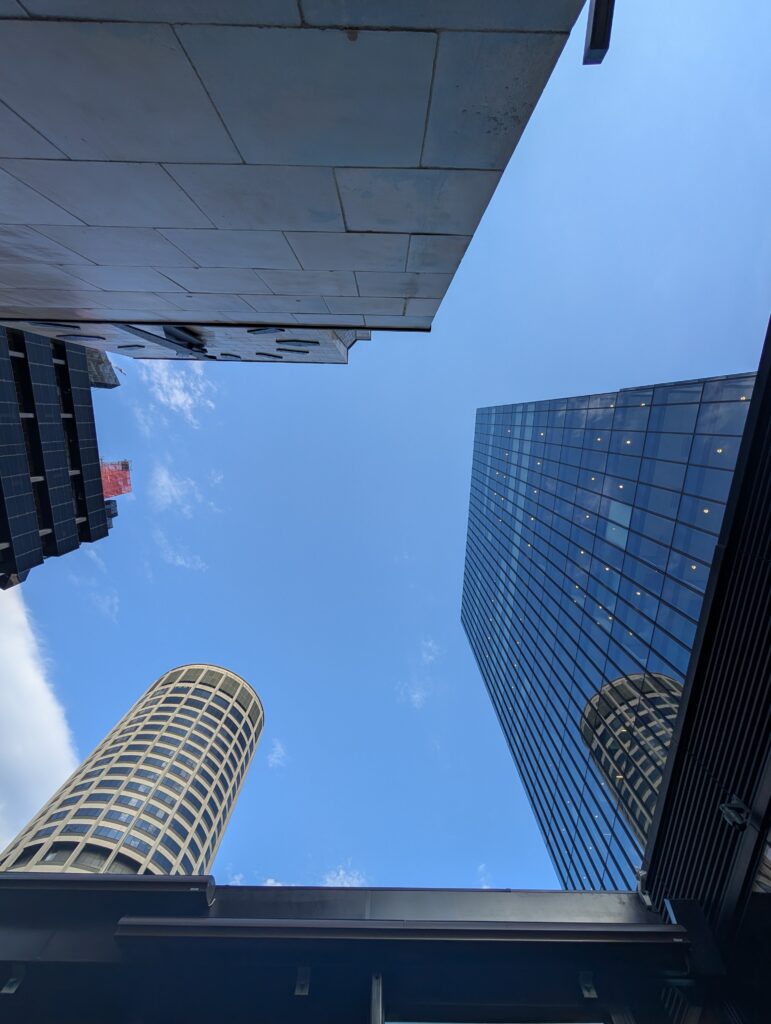 How to build a Brand Awareness Program - strategies vs tactics A photo under 3 high-rise buildings and a blue sky.