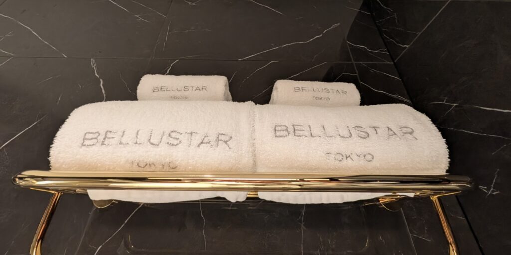 Local Secrets Edition 4: The Penthouse In The Sky. Image of Bellustar Tokyo white folded towels against a black and white marbled wall.