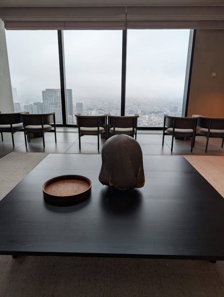 Local Secrets Edition 4: The Penthouse In The Sky. Image of a coffee table with two pieces of minimalist art with the Tokyo Skyline backdrop through floor-to-ceiling windows.